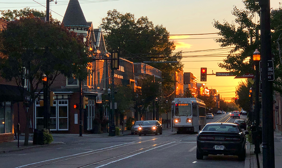 An image of a trolley at a stop light during sunrise