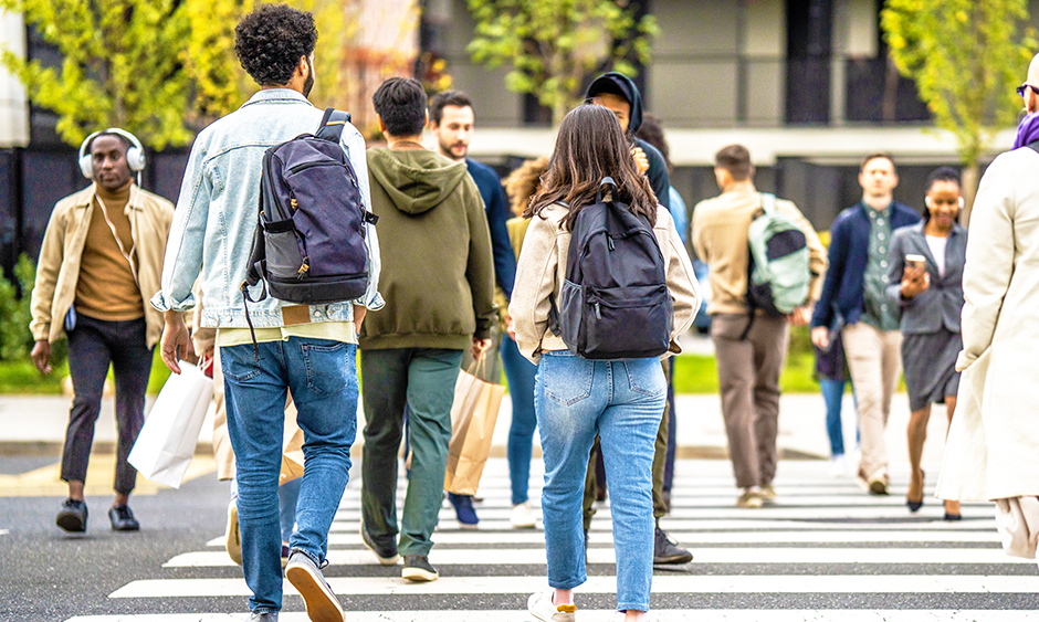 People cross in both directions at a busy crosswalk