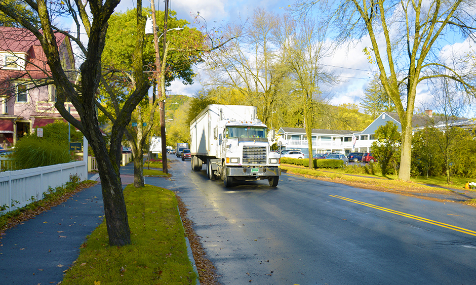 A semi hauling freight drives on a residential street