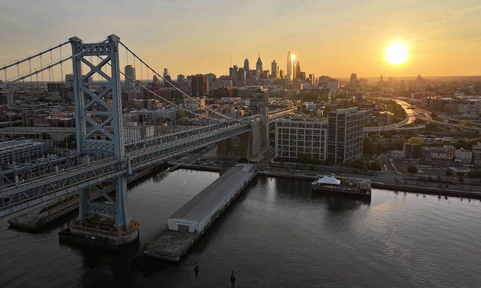 The Ben Franklin Bridge with the sun setting on the Philadelphia skyline in the background,