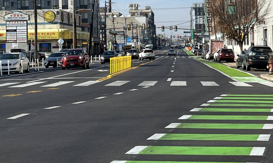 Intersection of a roadway in Philadelphia showing freshly painted green crosswalks and bicycle lanes.