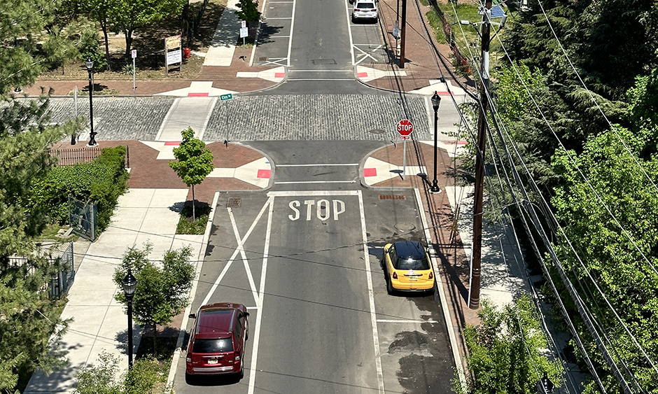 An aerial view of an intersection and tree-lined streets